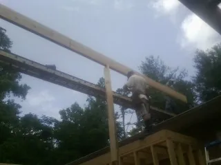 Carpenter setting a ridge beam over a new addition frame — Ice Dam Removal by Roofing Brothers in Mount Laurel