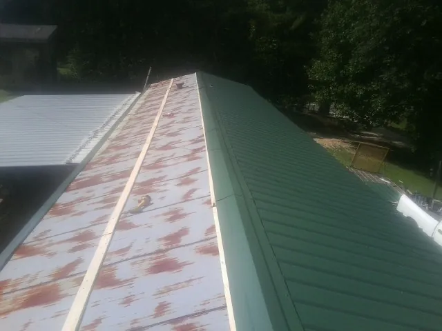 Old rusted panels beside newly installed green metal roofing — Wind Damage Roof Repair by Roofing Brothers in Mount Laurel