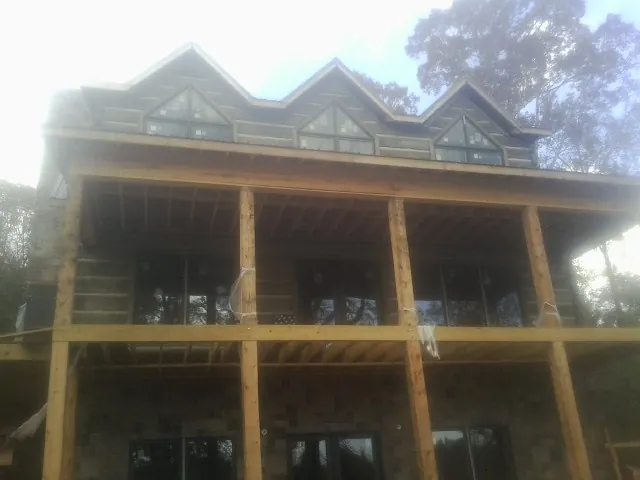Dormers and porch framing on a large log home under construction — Roof Coating work by our crew in Mount Laurel