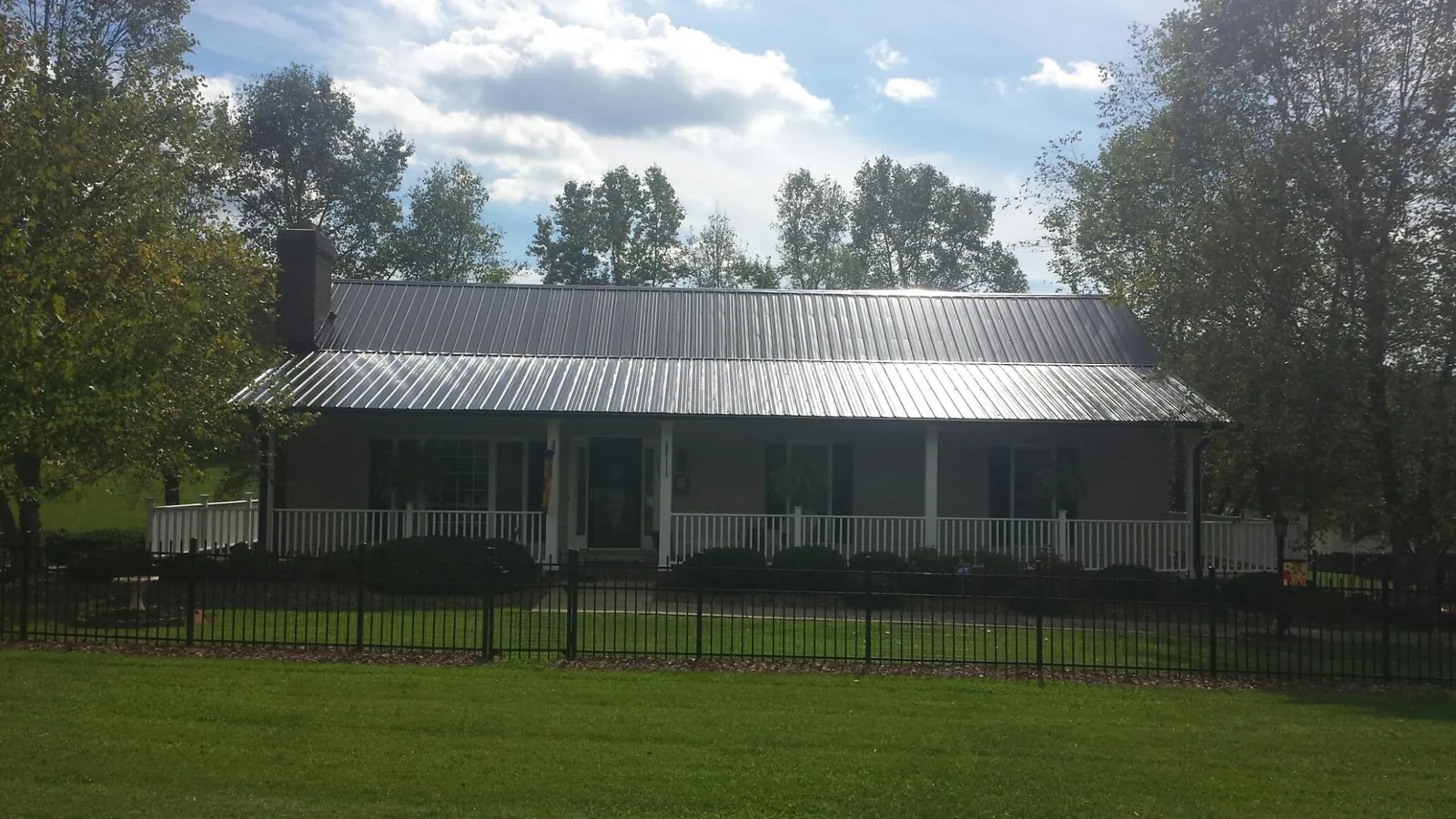 Gray metal roof on a brick ranch with a full width front porch — Gutter Guard Installation work by our crew in Mount Laurel