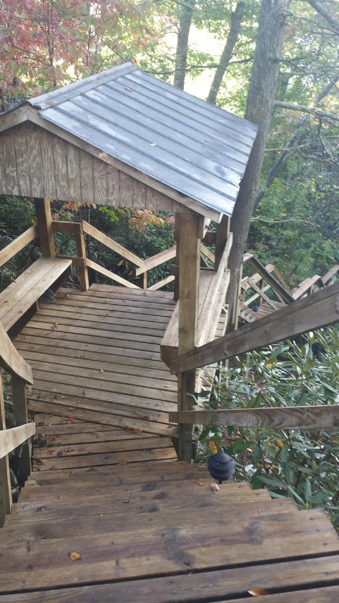 Metal roofed shelter over wooden steps on a wooded walkway — Skylight Repair & Installation work by our crew in Mount Laurel